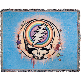 A blue woven cotton blanket with a Grateful Dead Steal Your Face Skull, with a full circle rainbow in the center of the skull, spray paint splatters filling in the circle around it, and dripping around the edges, and stars scattered around the edges of the circle.