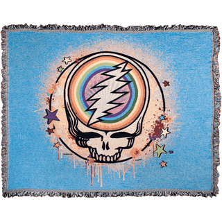 A blue woven cotton blanket with a Grateful Dead Steal Your Face Skull, with a full circle rainbow in the center of the skull, spray paint splatters filling in the circle around it, and dripping around the edges, and stars scattered around the edges of the circle.